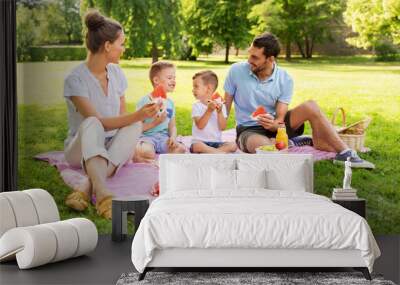 family, leisure and people concept - happy mother, father and two little sons having picnic and eating watermelon at summer park Wall mural