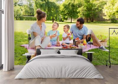 family, leisure and people concept - happy mother, father and two little sons having picnic and eating watermelon at summer park Wall mural