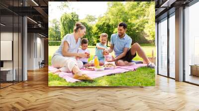 family, leisure and people concept - happy mother, father and two little sons having picnic at summer park Wall mural