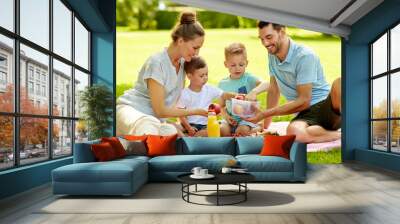 family, leisure and people concept - happy mother, father and two little sons having picnic at summer park Wall mural