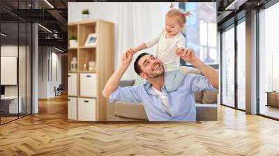 family, parenthood and fatherhood concept - happy father riding little baby daughter on his neck at home Wall mural