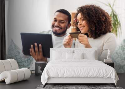 family, technology, online shopping and people concept - happy african american couple couple with tablet pc computer and credit card at home Wall mural