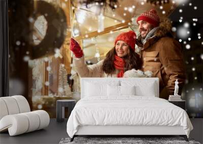 family, winter holidays and celebration concept - happy mother, father and little daughter at christmas market on town hall square in tallinn, estonia over snow Wall mural