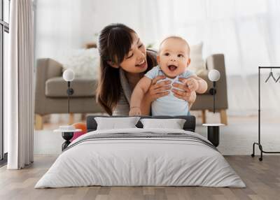 family and motherhood concept - happy smiling young asian mother with little baby at home Wall mural