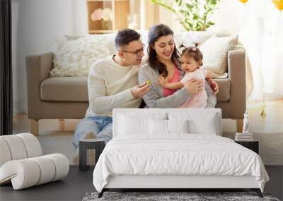 family and people concept - happy mother, father and little daughter at home Wall mural