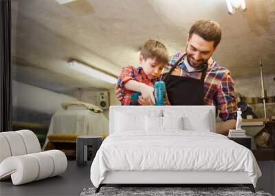 father and son with drill working at workshop Wall mural