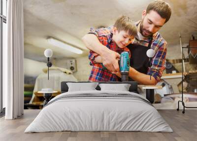 father and son with drill working at workshop Wall mural