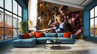 father and son with hammer working at workshop Wall mural