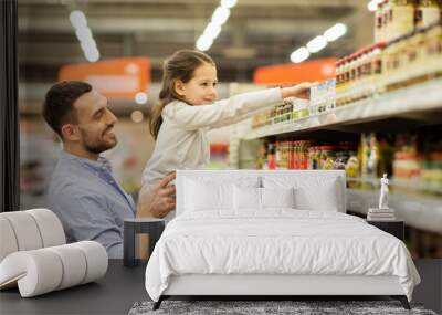 father with child buying food at grocery store Wall mural