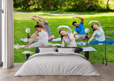 fitness, sport and healthy lifestyle concept - group of happy people exercising at summer park Wall mural