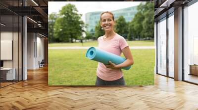 fitness, sport and healthy lifestyle concept - happy smiling woman with exercise mat at park Wall mural