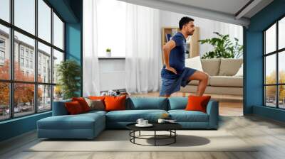 fitness, sport and healthy lifestyle concept - indian man exercising and doing lunge at home Wall mural