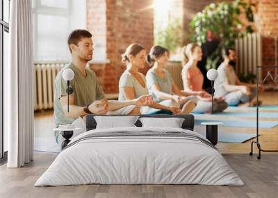 fitness, yoga and healthy lifestyle concept - group of people meditating in lotus pose at studio Wall mural