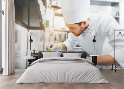 food cooking, profession and people concept - happy male chef cook serving and garnishing stewed veg Wall mural