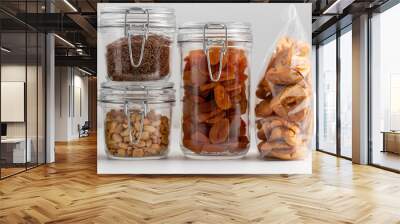 food storage, healthy eating and diet concept - close up of jars with dried fruits, seeds and nuts on table Wall mural