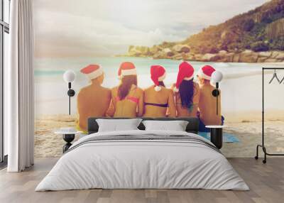 friends in santa hats on beach at christmas Wall mural