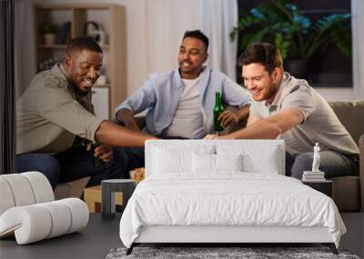 friendship, leisure and people concept - male friends drinking beer and eating crisps at home at night Wall mural