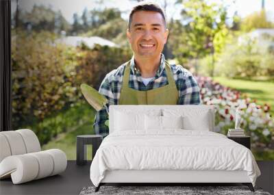 gardening and people concept - happy smiling middle-aged man in apron with trowel in crossed hands at summer garden Wall mural