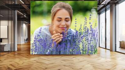 gardening and people concept - happy young woman smelling lavender flowers at summer garden Wall mural