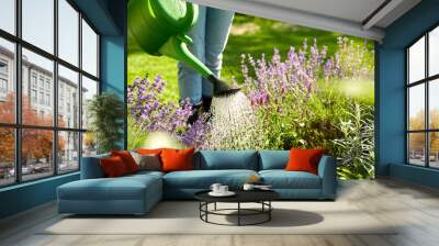 gardening and people concept - young woman with watering can pouring water to flowers at garden Wall mural