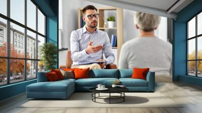 geriatric psychology, mental therapy and old age concept - psychologist talking to senior woman patient at psychotherapy session Wall mural