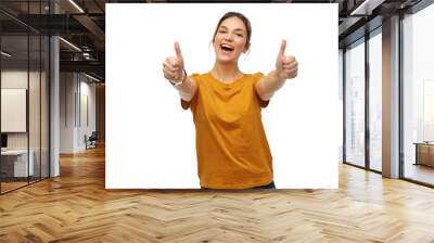 gesture and people concept - happy smiling young woman or teenage girl in orange t-shirt showing thumbs up over white background Wall mural