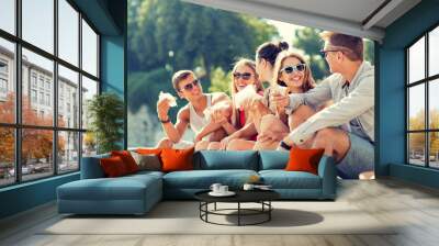 group of smiling friends sitting on city square Wall mural