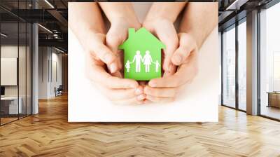 hands holding green house with family Wall mural