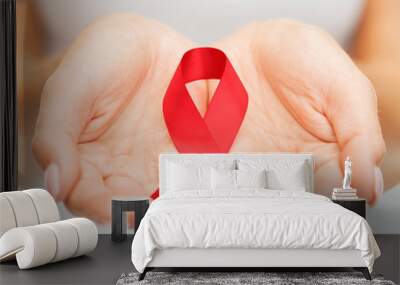 hands holding red AIDS awareness ribbon Wall mural