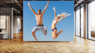 happy couple jumping on the beach Wall mural