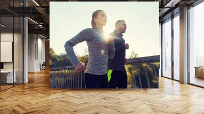 happy couple running outdoors Wall mural