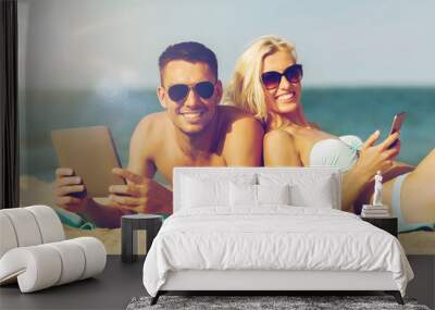 happy couple with tablet pc sunbathing on beach Wall mural