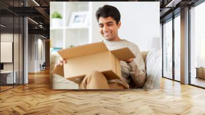 happy man opening parcel box at home Wall mural