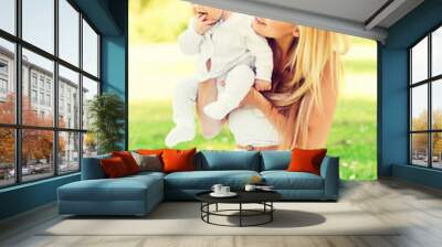 happy mother with little baby sitting on blanket Wall mural