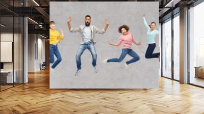 happy people or friends jumping in air over gray Wall mural