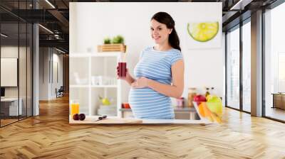 happy pregnant woman drinking juice at home Wall mural