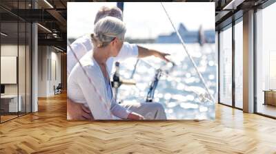 happy senior couple on sail boat or yacht in sea Wall mural