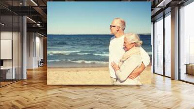 happy senior couple walking along summer beach Wall mural