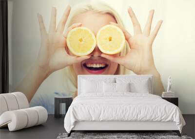 happy woman having fun covering eyes with lemon Wall mural