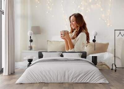 happy woman with cup of coffee in bed at home Wall mural