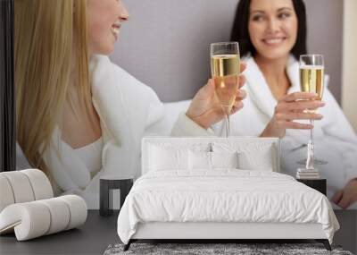 happy women in bathrobes with champagne glasses Wall mural