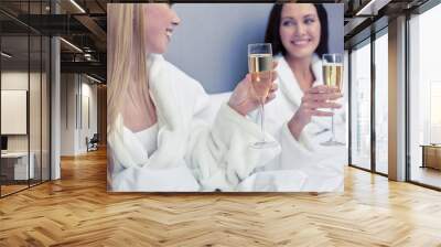 happy women in bathrobes with champagne glasses Wall mural