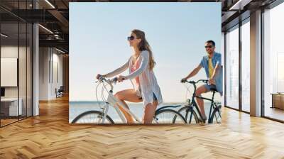 happy young couple riding bicycles at seaside Wall mural