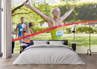 happy young female runner winning on race finish Wall mural