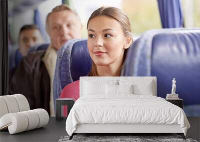 happy young woman sitting in travel bus or train Wall mural