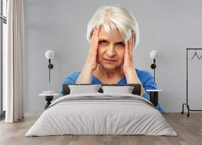 health, stress and old people concept - senior woman suffering from headache Wall mural