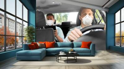 health care, safety and pandemic concept - male taxi driver driving car and passenger wearing face protective mask for protection from virus disease Wall mural