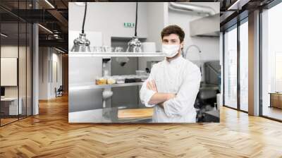 health protection, safety and pandemic concept - male chef cook wearing face protective medical mask over restaurant kitchen background Wall mural