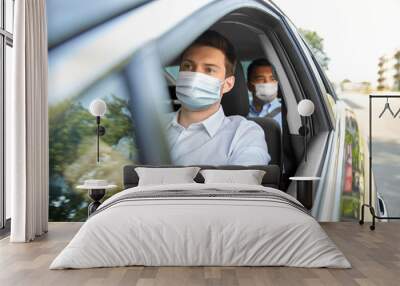 health protection, safety and pandemic concept - male taxi driver wearing face protective medical mask driving car with passenger Wall mural