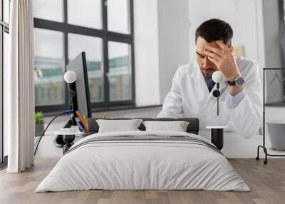 healthcare, medicine and people concept - stressed male doctor with clipboard at hospital Wall mural